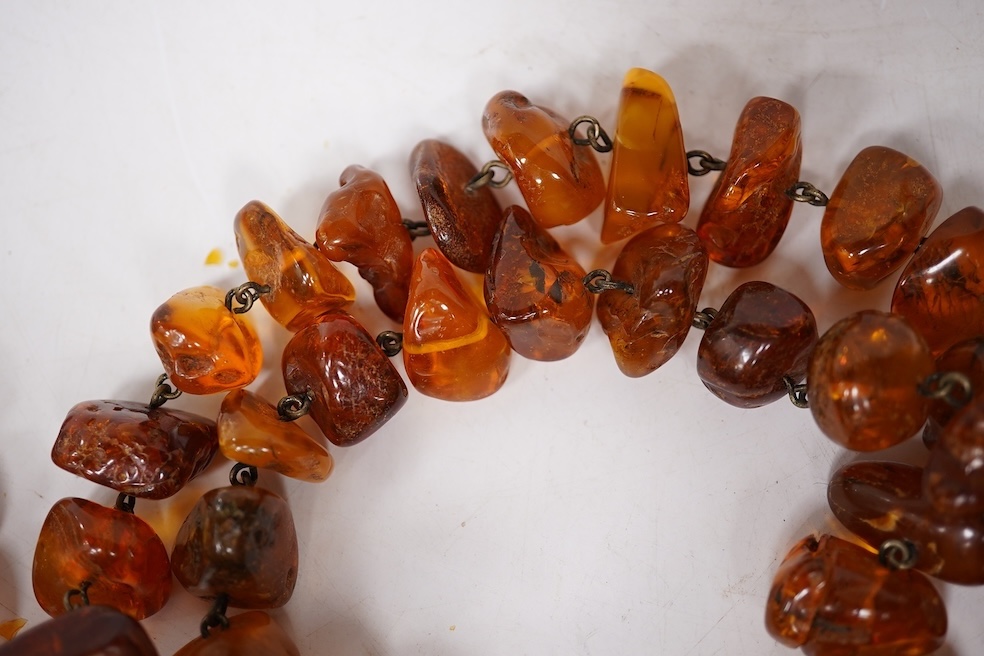 Three assorted amber necklaces including a single strand graduated oval bead necklace, 40cm, gross weight 37 grams, the other two necklaces gross weight 240 grams. Condition - poor to fair